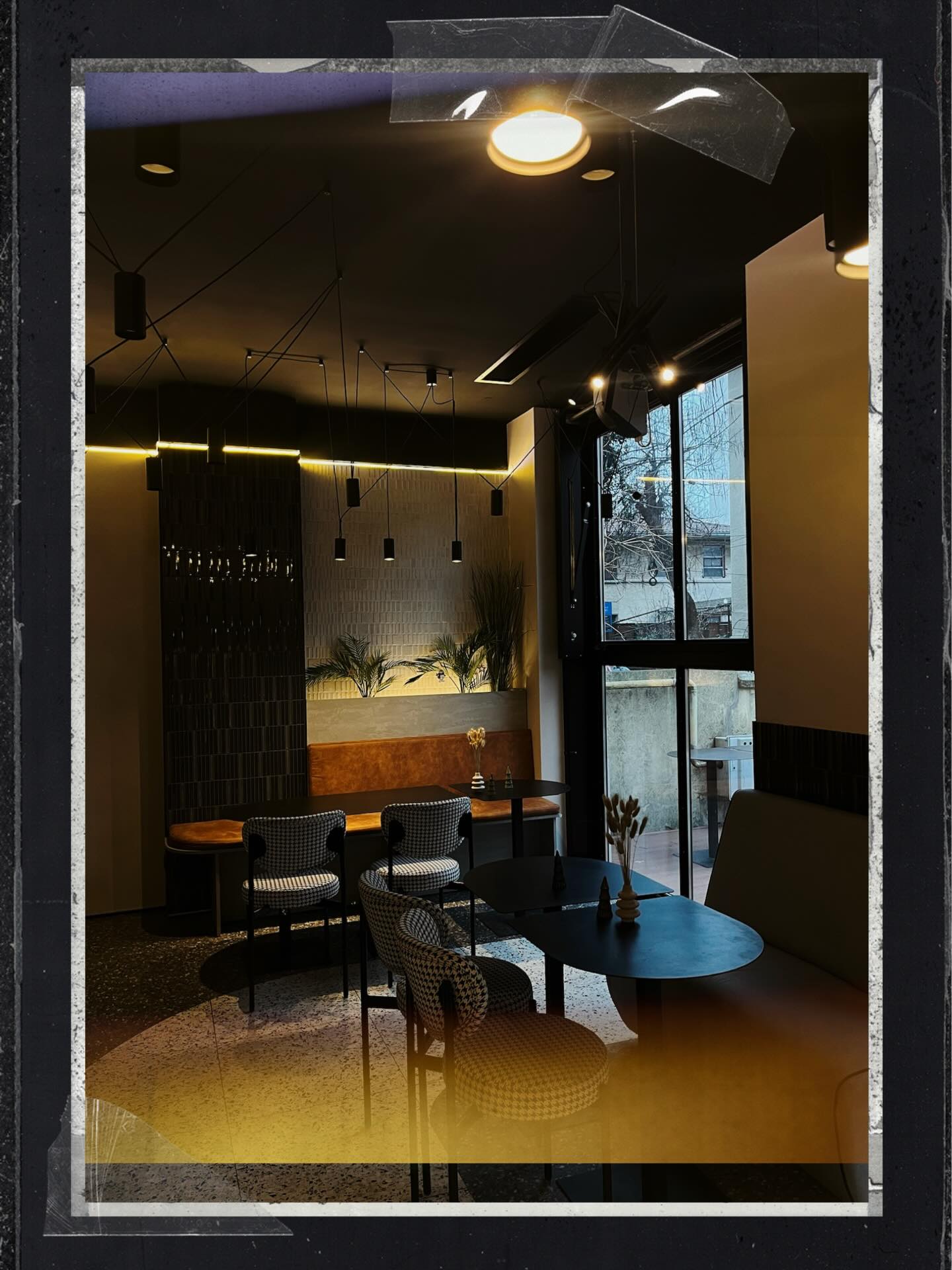 Interior by evening — the leather banquette and houndstooth chairs